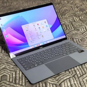 A sleek modern laptop with an open application menu on a patterned surface.